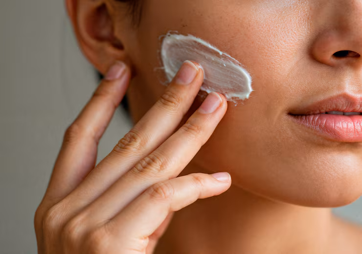 Woman applying face cream to her skin