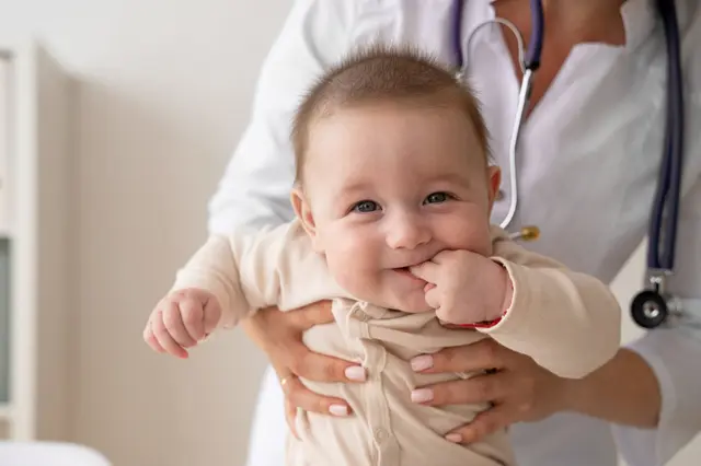 Front view doctor holding baby